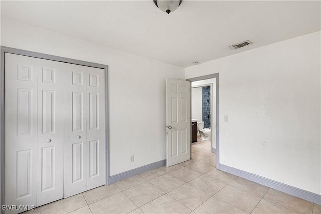 unfurnished bedroom featuring light tile patterned floors and a closet