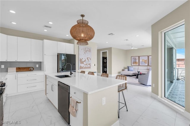 kitchen featuring a kitchen island, sink, dishwasher, white cabinetry, and hanging light fixtures