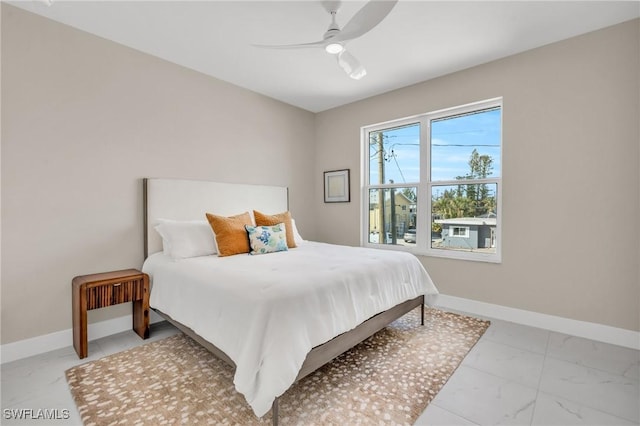 bedroom featuring marble finish floor, ceiling fan, and baseboards