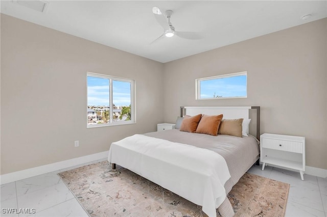 bedroom with marble finish floor, a ceiling fan, and baseboards