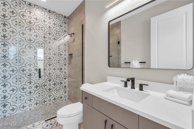 bathroom with vanity, toilet, and a shower with door