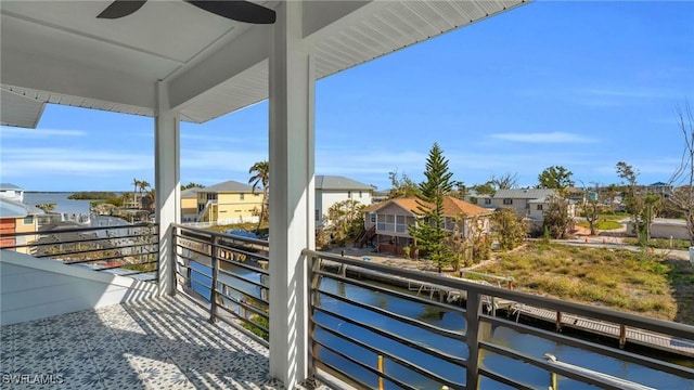 balcony with ceiling fan and a water view