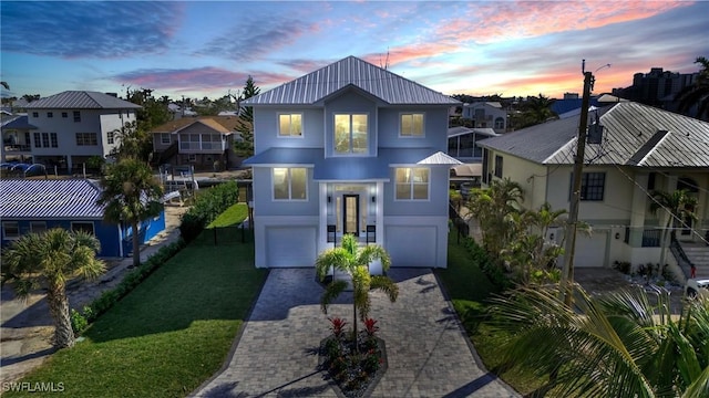 view of front facade with a garage, a front yard, decorative driveway, and a residential view