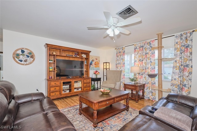 living room with light wood-type flooring and ceiling fan