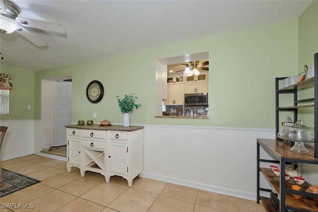 kitchen with ceiling fan, white cabinets, and light tile patterned floors