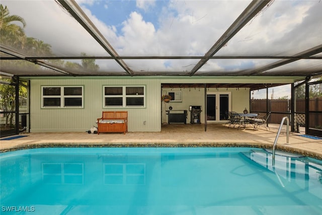 view of pool featuring glass enclosure, a patio area, and french doors