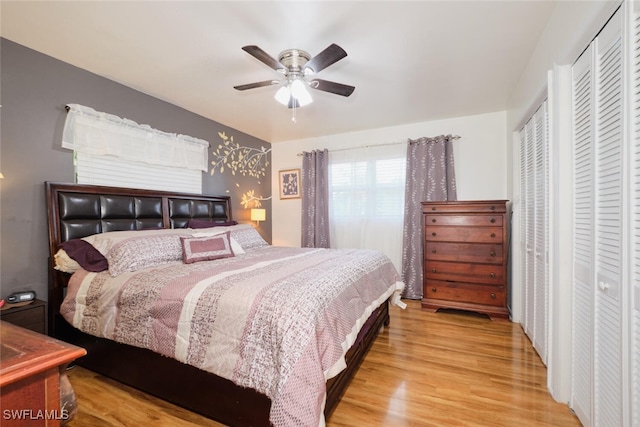 bedroom with ceiling fan, light wood-type flooring, and a closet