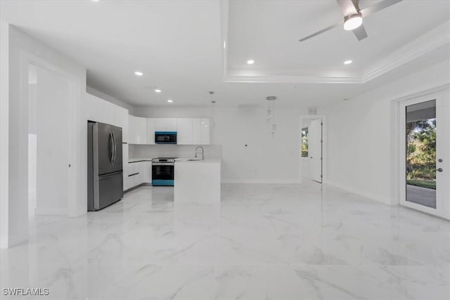 kitchen featuring pendant lighting, a raised ceiling, sink, white cabinetry, and stainless steel appliances