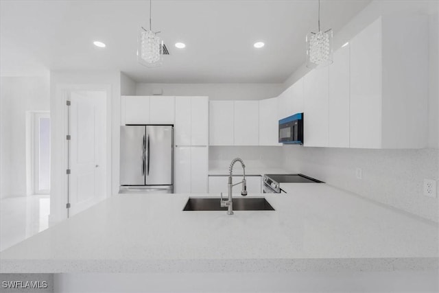 kitchen with a notable chandelier, decorative light fixtures, stainless steel fridge, and white cabinets