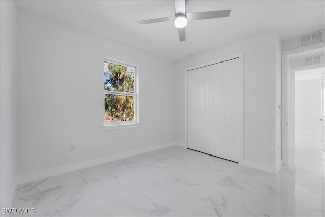 unfurnished bedroom with ceiling fan and a closet