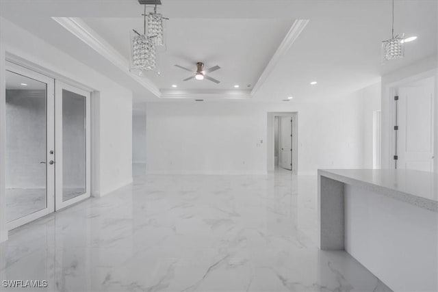 unfurnished room featuring ceiling fan with notable chandelier, a raised ceiling, crown molding, and french doors