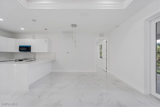 kitchen with white cabinetry, pendant lighting, and ornamental molding