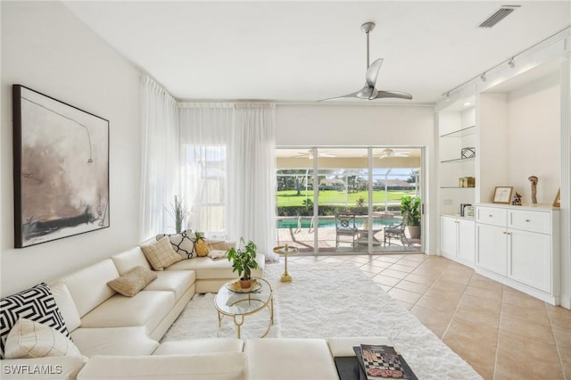 tiled living room featuring ceiling fan and rail lighting