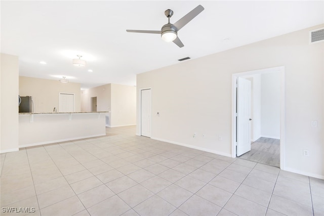 unfurnished living room with ceiling fan and light tile patterned floors