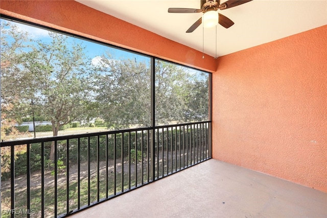 unfurnished sunroom featuring ceiling fan