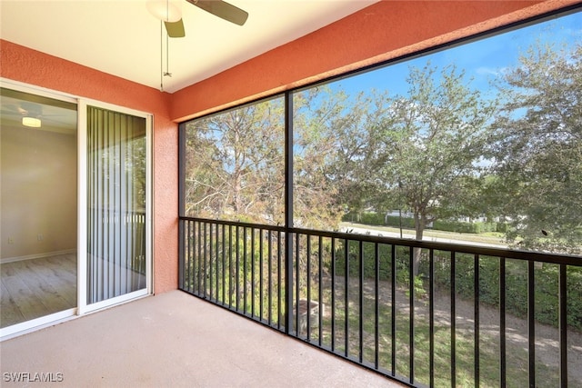 unfurnished sunroom with ceiling fan