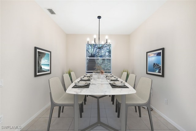 dining area with light tile patterned flooring and a chandelier