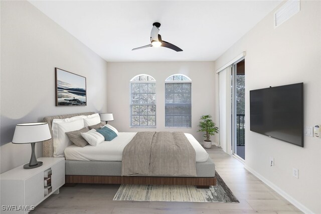 bedroom featuring light wood-type flooring, access to outside, multiple windows, and ceiling fan