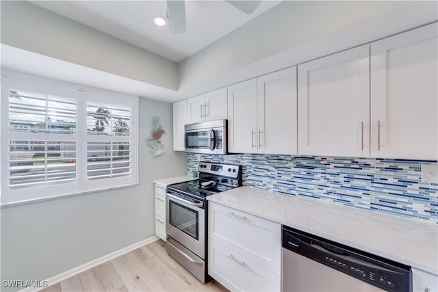 kitchen with white cabinetry, stainless steel appliances, tasteful backsplash, and light hardwood / wood-style flooring