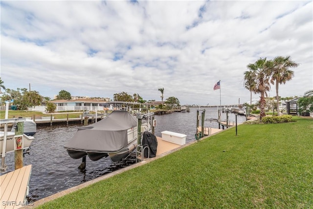 view of dock with a lawn and a water view