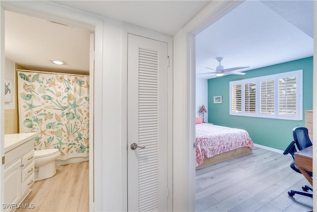 bedroom featuring ensuite bathroom, a closet, ceiling fan, and light wood-type flooring