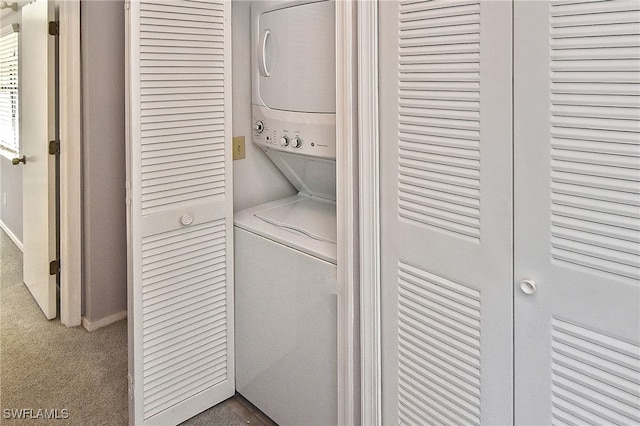 laundry room with carpet floors and stacked washer / dryer