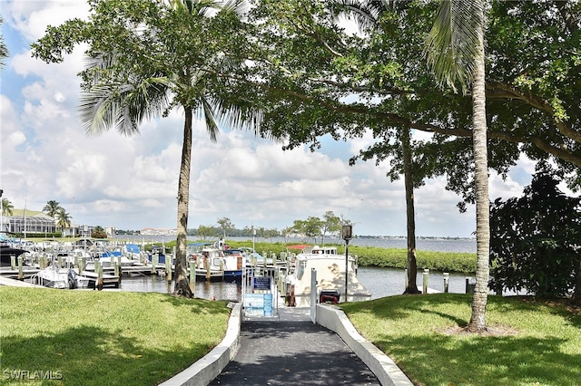 dock area featuring a lawn and a water view