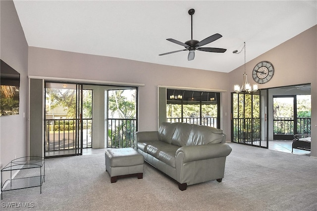 living room featuring high vaulted ceiling, light colored carpet, and ceiling fan with notable chandelier