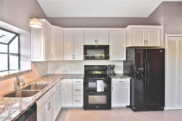 kitchen with black appliances, sink, decorative light fixtures, light stone counters, and white cabinetry