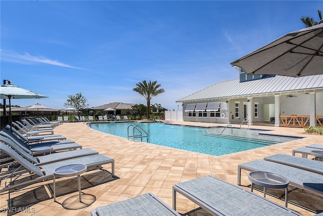 view of swimming pool with ceiling fan and a patio