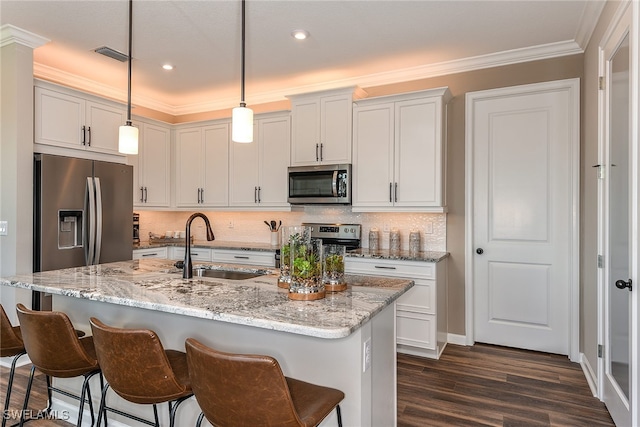 kitchen with white cabinetry, pendant lighting, and stainless steel appliances