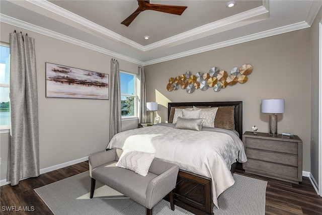 bedroom with ceiling fan, dark hardwood / wood-style flooring, crown molding, and a tray ceiling