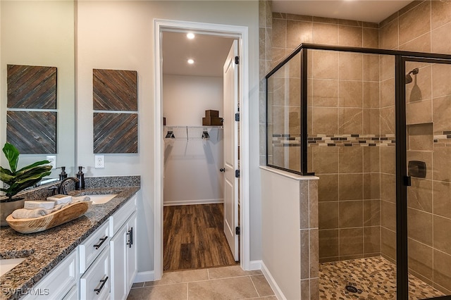 bathroom featuring wood-type flooring, vanity, and an enclosed shower