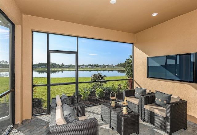 sunroom / solarium featuring a water view