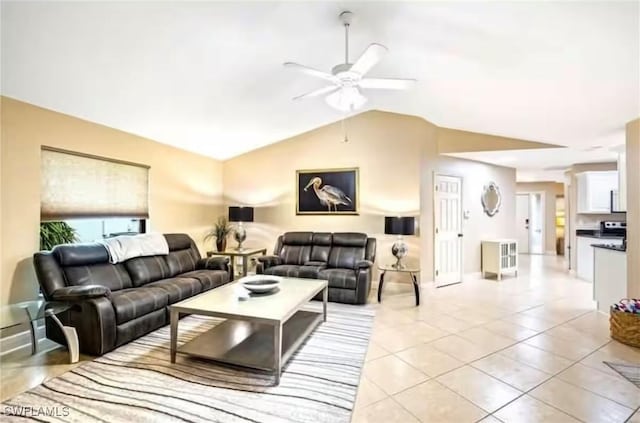 living room featuring ceiling fan, light tile patterned floors, and vaulted ceiling