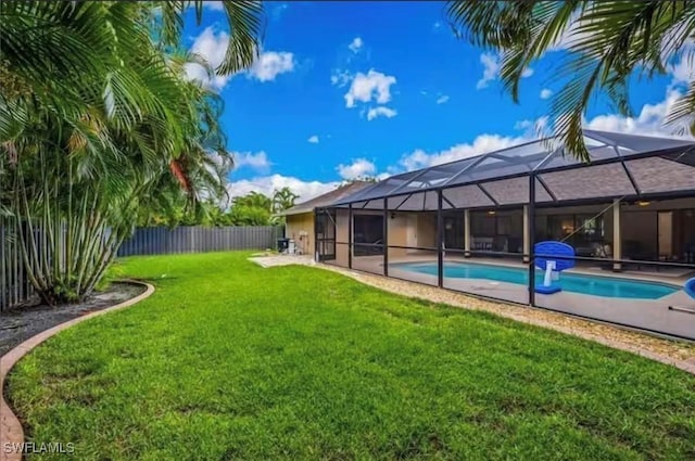 view of yard featuring a fenced in pool and glass enclosure