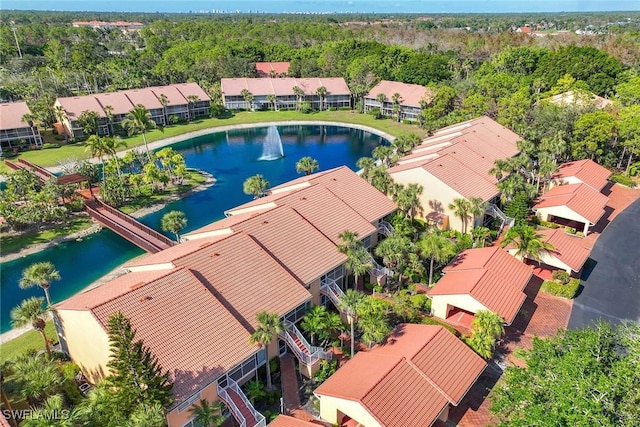 birds eye view of property with a water view, a residential view, and a view of trees