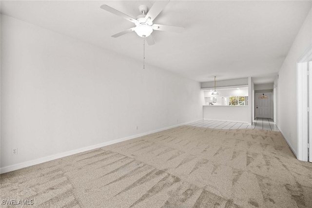 unfurnished living room featuring ceiling fan, carpet floors, and baseboards