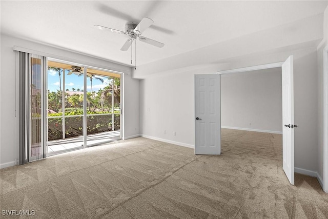 empty room with carpet flooring, a ceiling fan, and baseboards