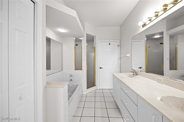 bathroom with double vanity, a sink, a shower stall, tile patterned flooring, and a bath