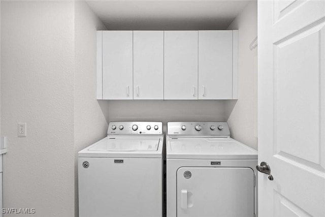 clothes washing area with cabinet space and washing machine and dryer