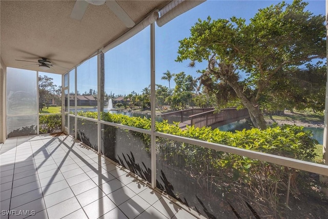 balcony featuring a water view and ceiling fan