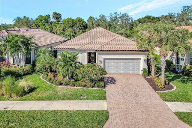 mediterranean / spanish-style home with stucco siding, a front lawn, a tile roof, decorative driveway, and a garage