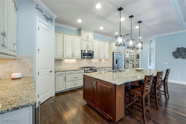 kitchen featuring light stone countertops, stainless steel appliances, dark hardwood / wood-style floors, hanging light fixtures, and an island with sink