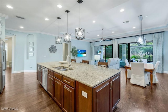 kitchen with appliances with stainless steel finishes, ceiling fan, a kitchen island with sink, sink, and hanging light fixtures