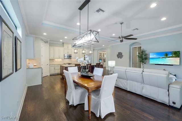 dining space featuring ceiling fan, crown molding, and dark wood-type flooring