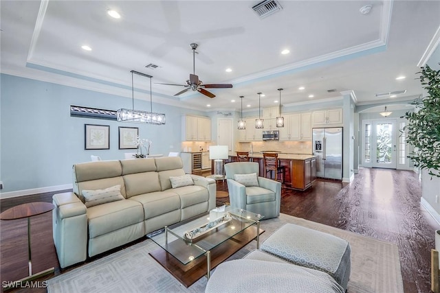 living room with french doors, a tray ceiling, ceiling fan, crown molding, and hardwood / wood-style flooring