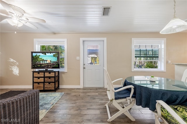 dining room with plenty of natural light, wood finished floors, visible vents, and baseboards