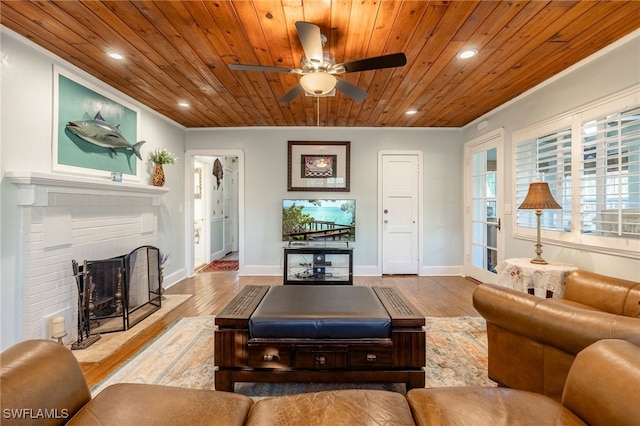 living room with light wood-type flooring, a brick fireplace, and wood ceiling