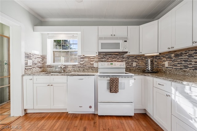 kitchen with light stone counters, white appliances, sink, and white cabinets